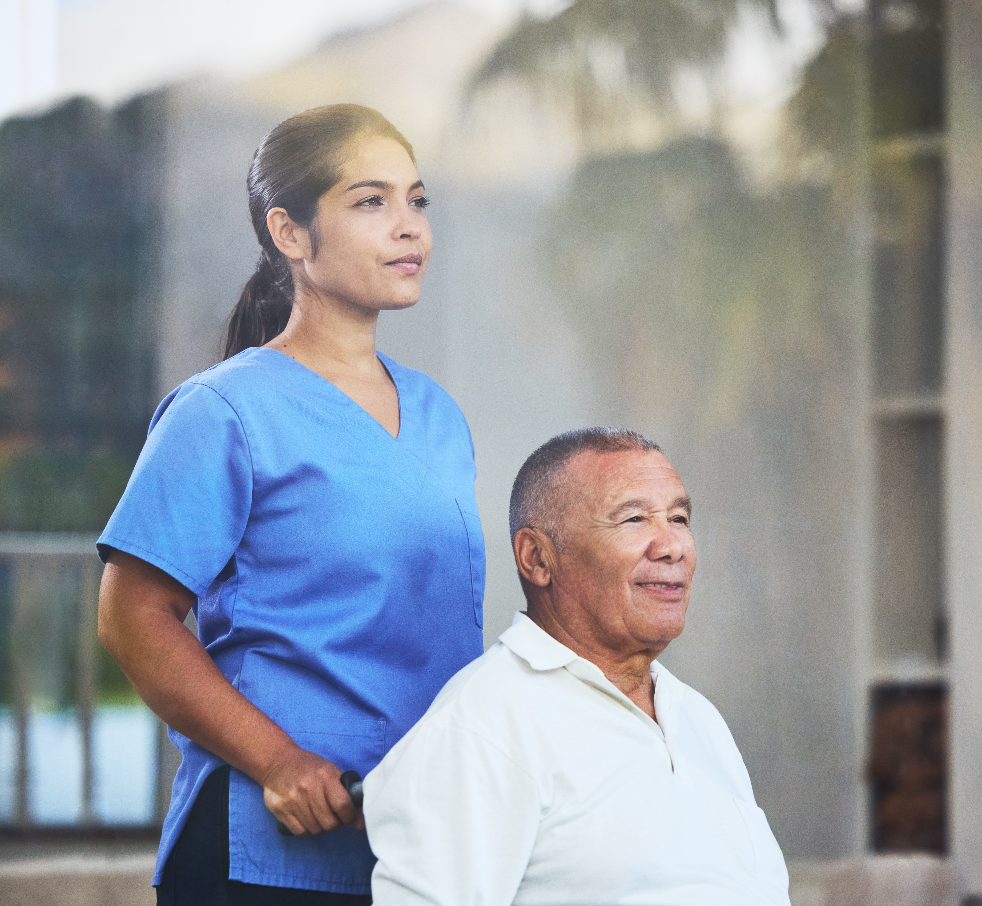 Home care nurse supporting an older adult in a wheelchair during daily living tasks